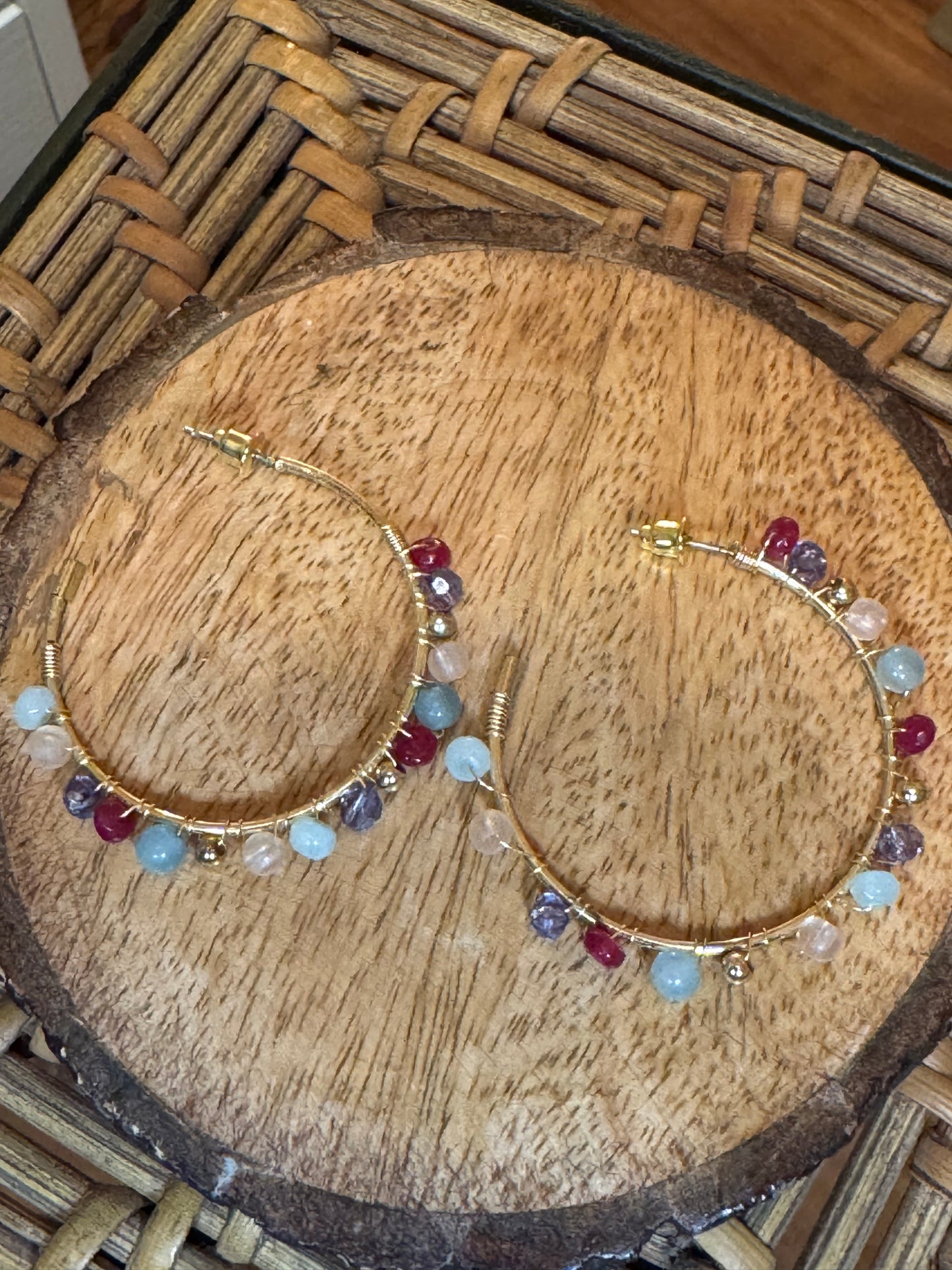 Gold tone hoop earrings adorned with small, multi-colored gemstone beads