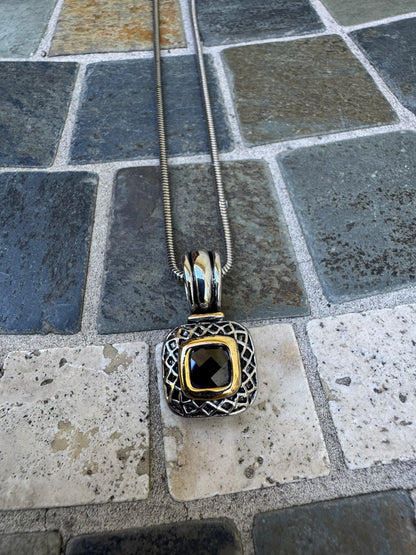 Pendant Necklace Featuring a Black Gemstone Set in a Textured Silver and Gold-accented Frame