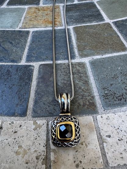 Pendant Necklace Featuring a Black Gemstone Set in a Textured Silver and Gold-accented Frame