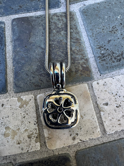 Pendant Necklace Featuring a Black Gemstone Set in a Textured Silver and Gold-accented Frame