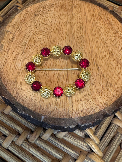 Vintage gold-tone brooch with red rhinestones