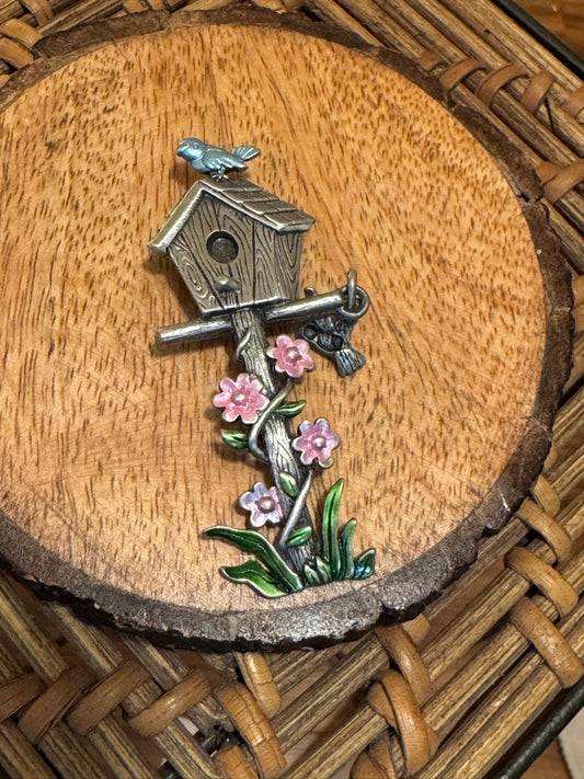 Vintage Signed Jonette Jewelry (JJ) brooch featuring a silver-tone birdhouse, a bluebird, and pink enamel flowers