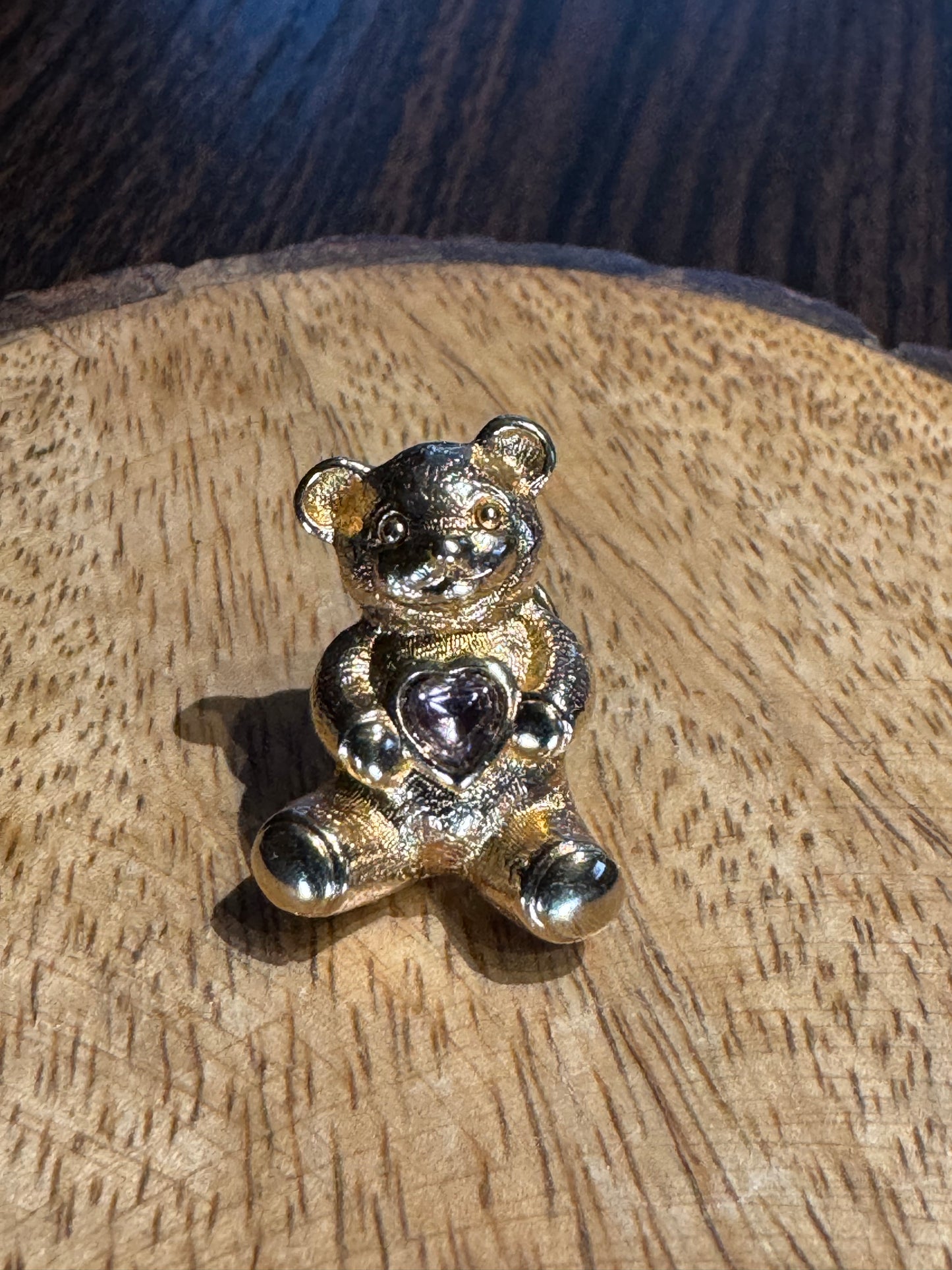 Vintage gold-tone Avon Bear lapel pin featuring a purple rhinestone heart