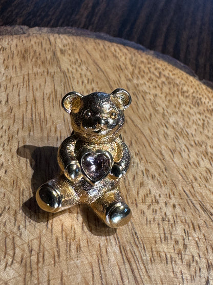 Vintage gold-tone Avon Bear lapel pin featuring a purple rhinestone heart