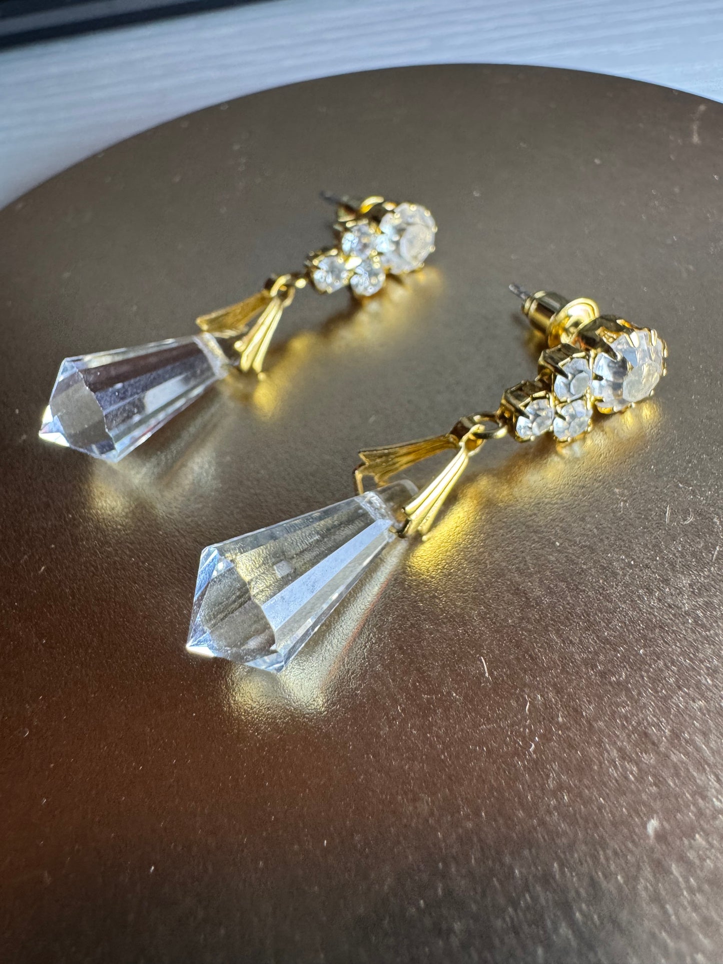Vintage inspired gold tone linear drop earrings featuring faceted clear glass crystal icicle drops