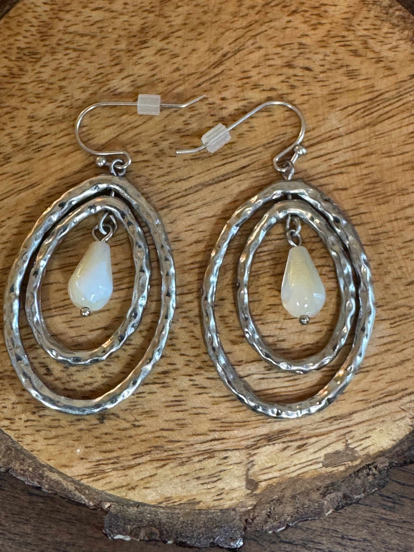 Lia Sophia earrings feature a silver-tone hammered oval design with a mother of pearl pearlescent drop