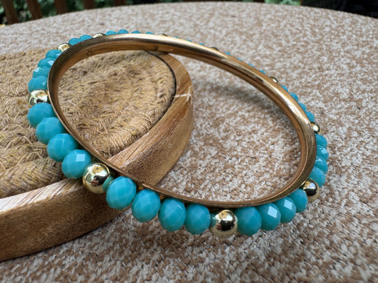 Gold-tone bangle bracelet featuring faceted turquoise-colored beads
