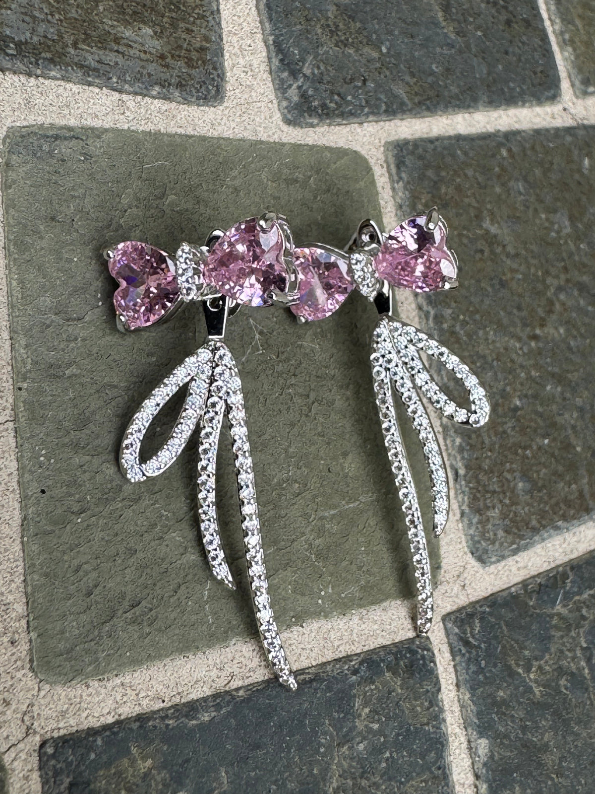 Silver-toned statement earrings featuring pink heart-shaped crystals and pave crystal