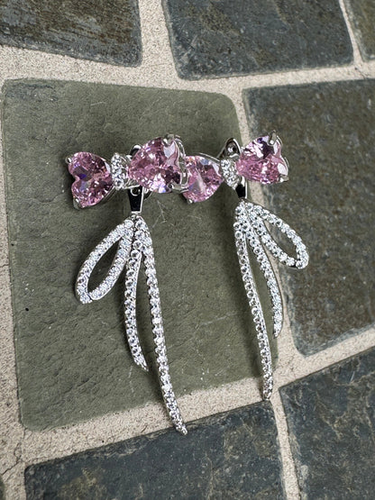 Silver-toned statement earrings featuring pink heart-shaped crystals and pave crystal