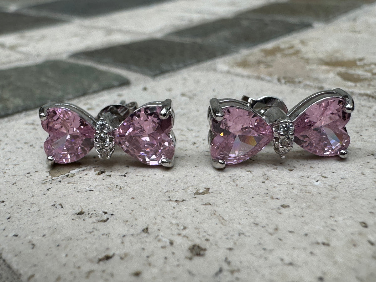 Silver-toned statement earrings featuring pink heart-shaped crystals and pave crystal