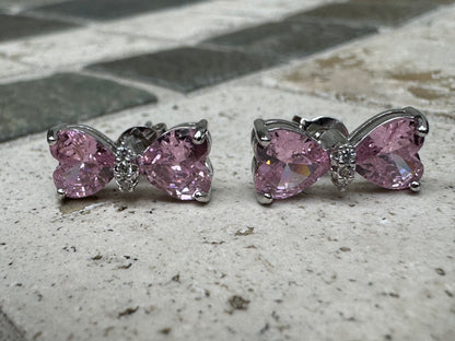 Silver-toned statement earrings featuring pink heart-shaped crystals and pave crystal